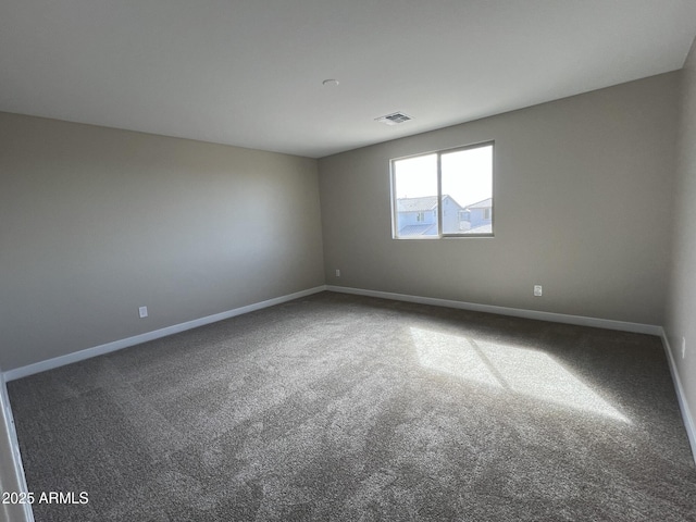 carpeted spare room with visible vents and baseboards