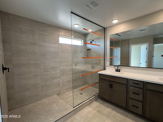 full bath with visible vents, vanity, and walk in shower