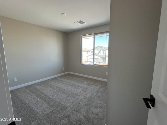 carpeted spare room with visible vents and baseboards