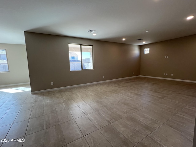 tiled empty room with a wealth of natural light, visible vents, recessed lighting, and baseboards