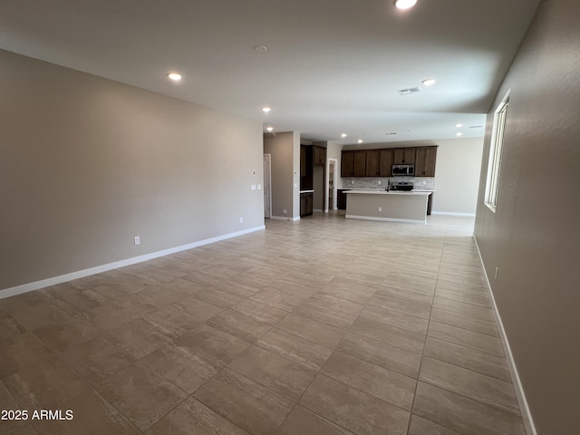 unfurnished living room with recessed lighting, visible vents, and baseboards