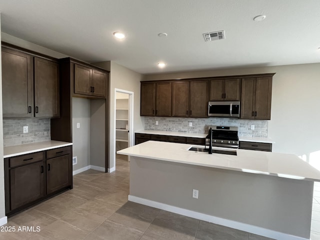 kitchen featuring a sink, visible vents, appliances with stainless steel finishes, and dark brown cabinets