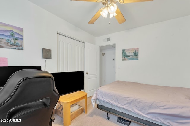 carpeted bedroom with ceiling fan and a closet