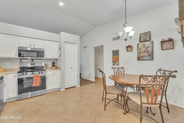 kitchen featuring hanging light fixtures, lofted ceiling, appliances with stainless steel finishes, and white cabinets