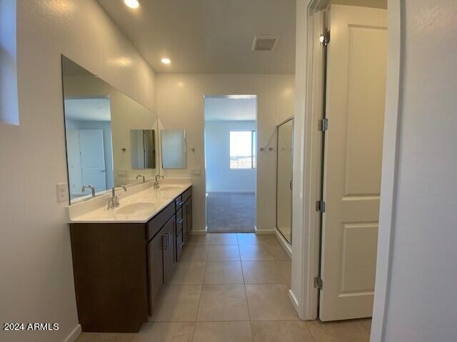 bathroom with vanity, tile patterned flooring, and walk in shower