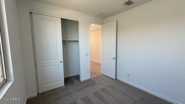 unfurnished bedroom with a closet and carpet flooring