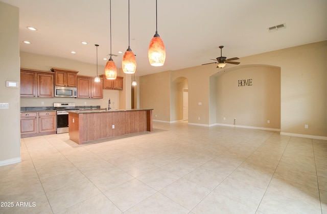 kitchen featuring sink, pendant lighting, ceiling fan, stainless steel appliances, and a kitchen island with sink