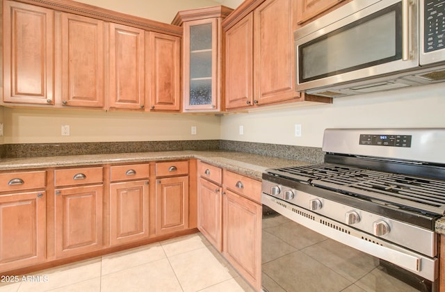 kitchen featuring light tile patterned flooring and appliances with stainless steel finishes