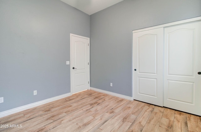 unfurnished bedroom featuring light wood-type flooring and a closet