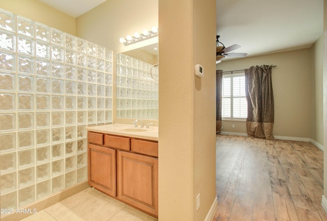 bathroom with hardwood / wood-style flooring, ceiling fan, and vanity