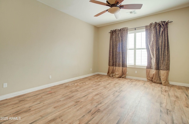 empty room with ceiling fan and light hardwood / wood-style flooring