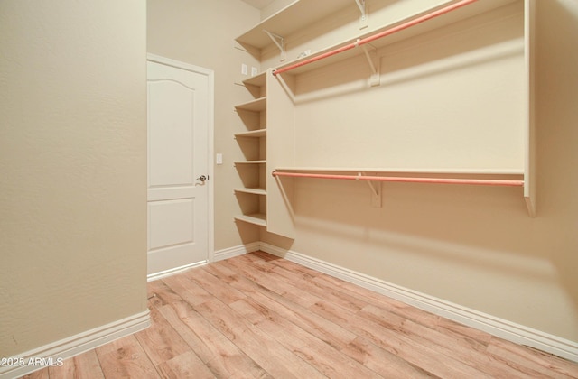 walk in closet with light hardwood / wood-style flooring