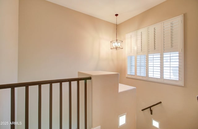 stairs featuring a chandelier