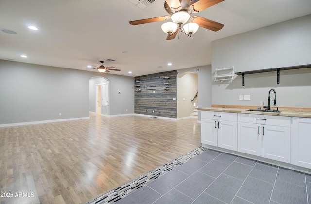 kitchen featuring dark wood-type flooring, ceiling fan, sink, and white cabinets