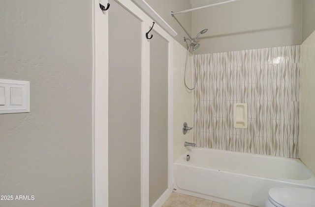 bathroom with tile patterned flooring, shower / bath combination, and toilet