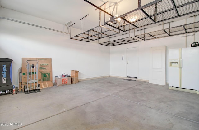 garage featuring white refrigerator with ice dispenser