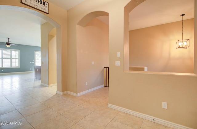 unfurnished room with light tile patterned floors and ceiling fan