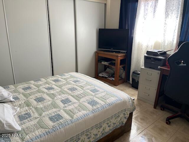 bedroom featuring light tile patterned floors and a closet