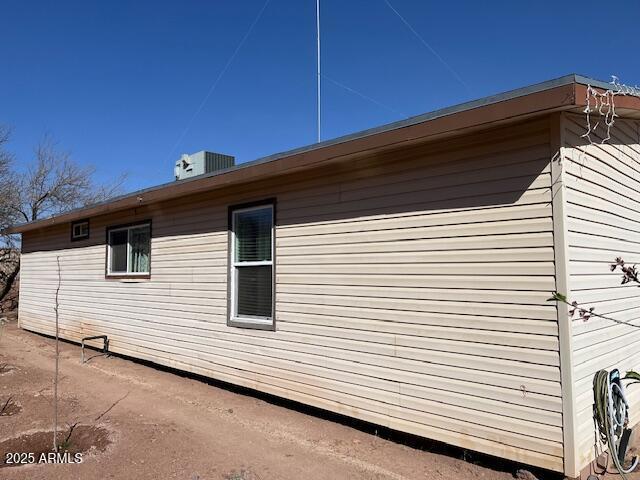 view of side of property with central air condition unit