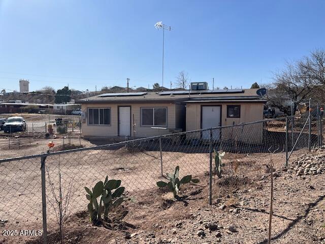 view of front of house featuring fence and solar panels