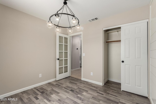 723 N Joshua Tree Ln, Gilbert, AZ 85234 - unfurnished bedroom featuring a chandelier, wood finished floors, french doors, and a closet