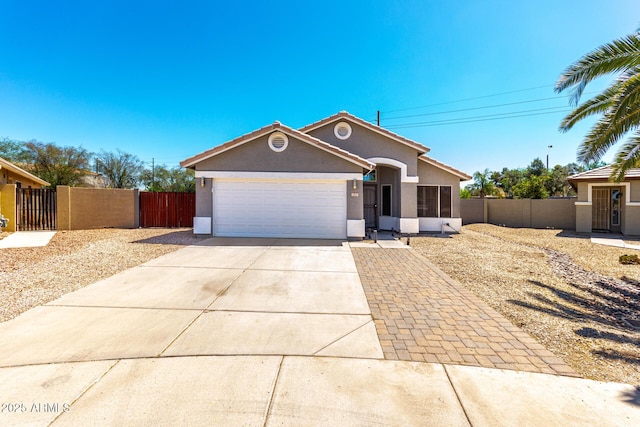 723 N Joshua Tree Ln, Gilbert, AZ 85234 - ranch-style house with driveway, stucco siding, an attached garage, and a gate