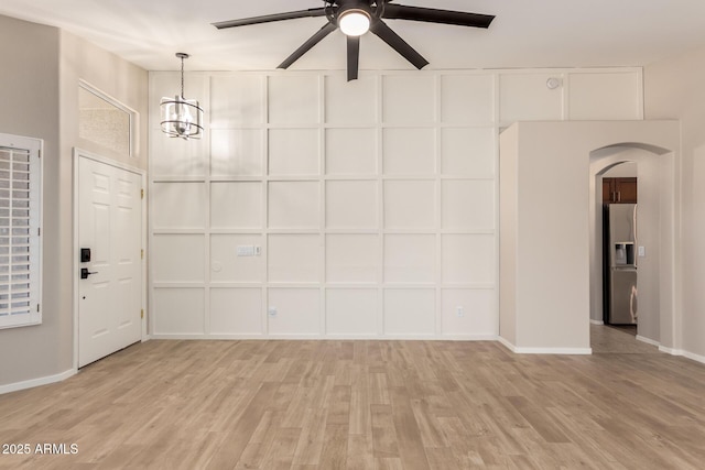723 N Joshua Tree Ln, Gilbert, AZ 85234 - unfurnished living room featuring arched walkways, light wood-type flooring, a ceiling fan, and a chandelier