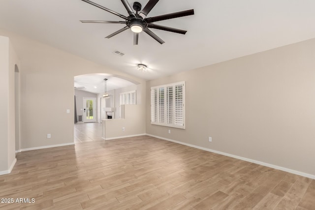 723 N Joshua Tree Ln, Gilbert, AZ 85234 - unfurnished living room with arched walkways, ceiling fan, light wood finished floors, and lofted ceiling