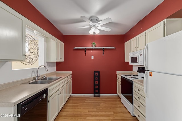 kitchen featuring white appliances, a sink, light countertops, white cabinets, and light wood-style floors