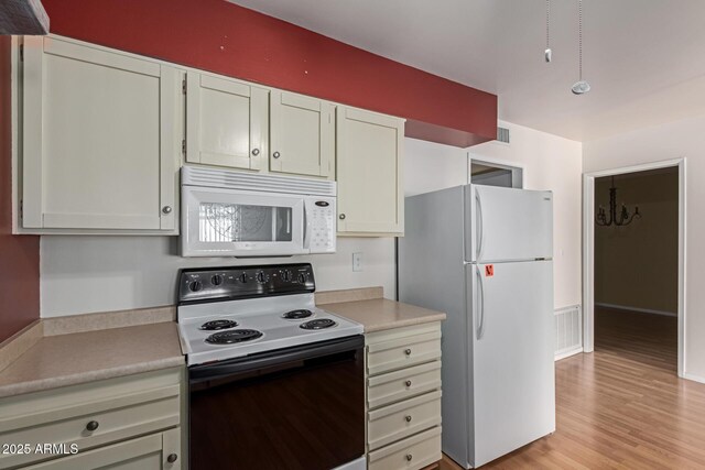 kitchen with visible vents, light wood-style flooring, white appliances, and light countertops