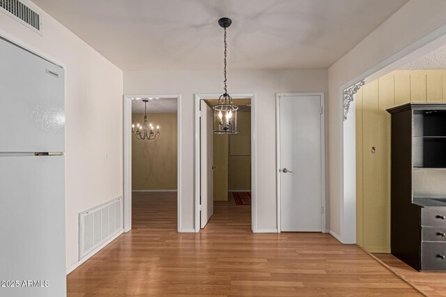 unfurnished dining area featuring visible vents and light wood-type flooring