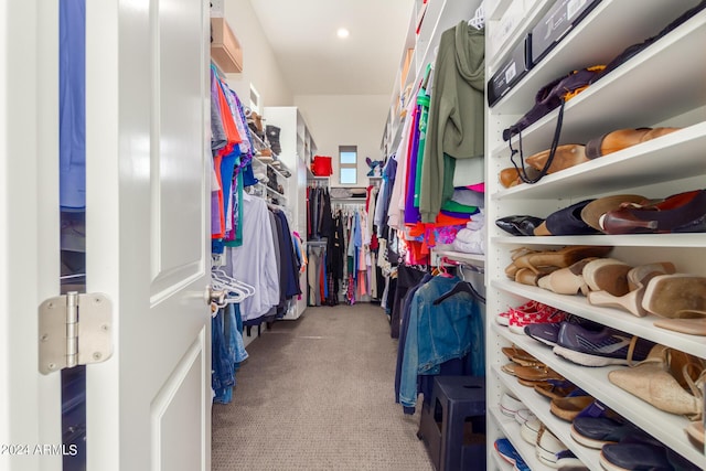 walk in closet featuring light colored carpet