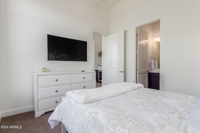 bedroom with ensuite bath and dark carpet