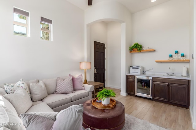 living room featuring light wood-type flooring, wine cooler, and wet bar