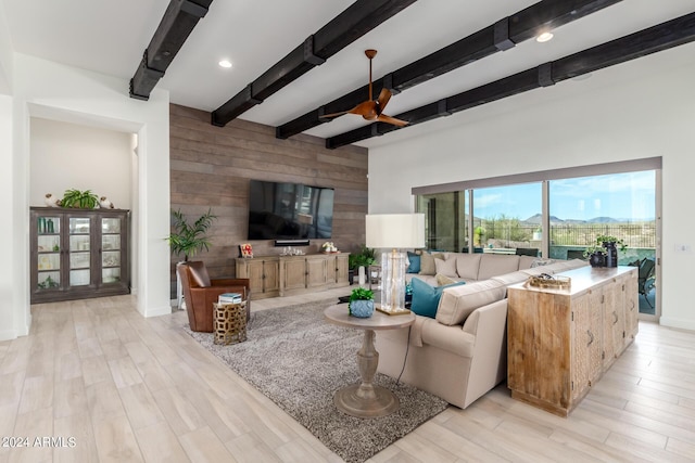 living room featuring light hardwood / wood-style floors, wood walls, and beam ceiling