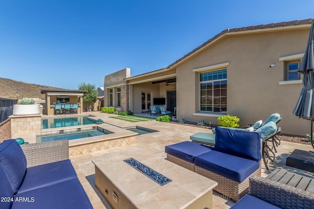 view of pool featuring an outdoor living space, an in ground hot tub, a patio area, and ceiling fan