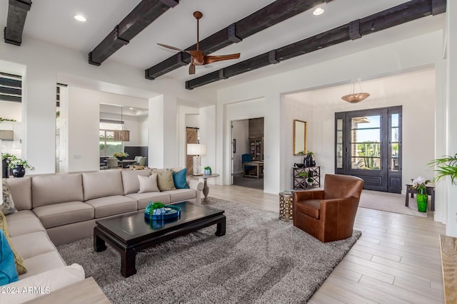 living room featuring light wood-type flooring, beam ceiling, and ceiling fan