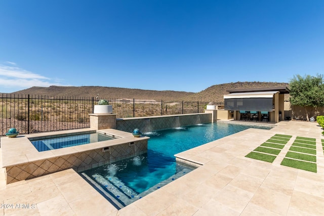 view of pool with exterior kitchen, an in ground hot tub, exterior bar, a mountain view, and pool water feature