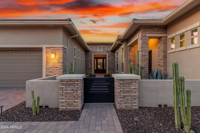 exterior entry at dusk with a garage