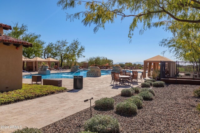 view of pool with pool water feature, a gazebo, and a patio