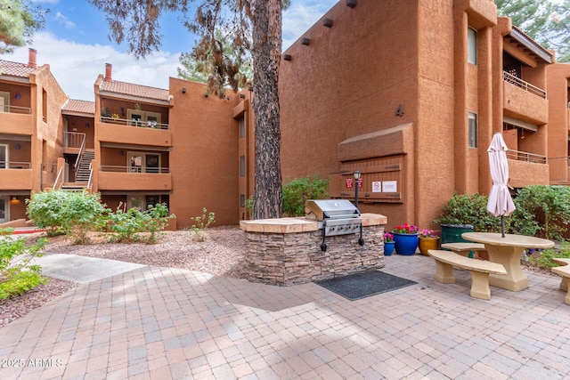 view of home's community with a patio area and area for grilling