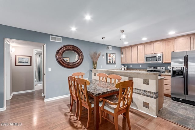 dining room with recessed lighting, visible vents, and wood finished floors