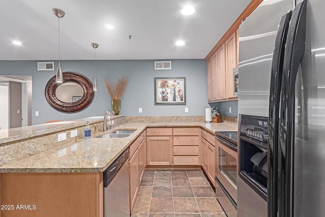 kitchen featuring stainless steel appliances, visible vents, a sink, and light brown cabinets