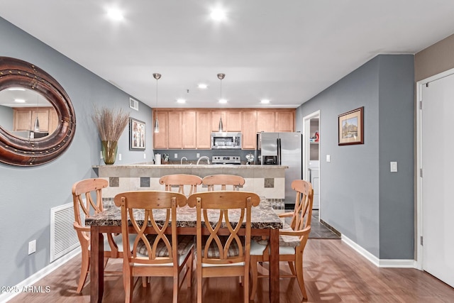 dining area with visible vents, baseboards, wood finished floors, and recessed lighting