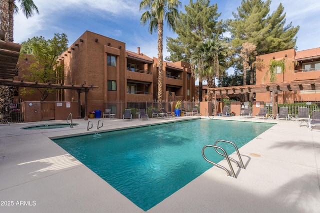 community pool featuring a patio area and fence