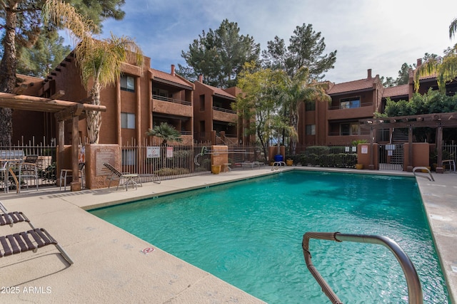 community pool with fence and a patio