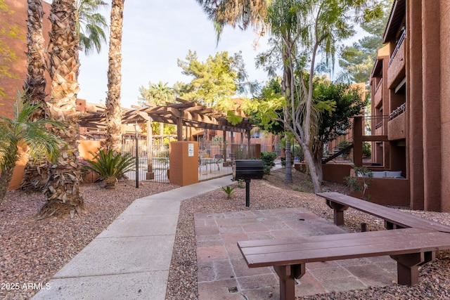 view of property's community featuring a gate, a patio area, fence, and stairs