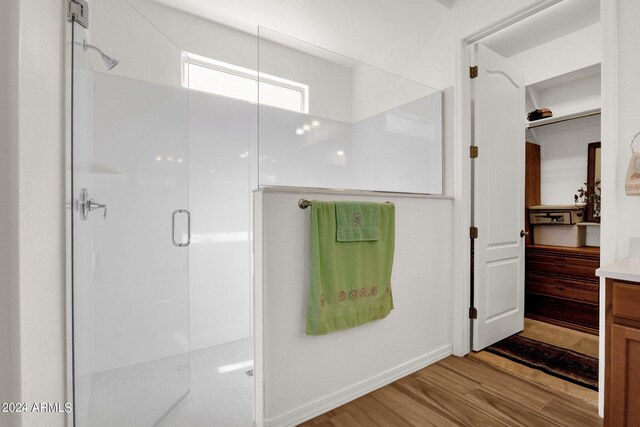 bathroom featuring wood-type flooring and a shower with shower door