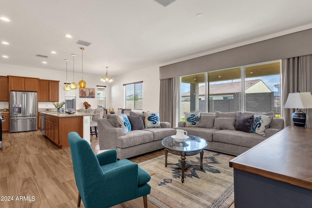 living room with light wood-type flooring and an inviting chandelier