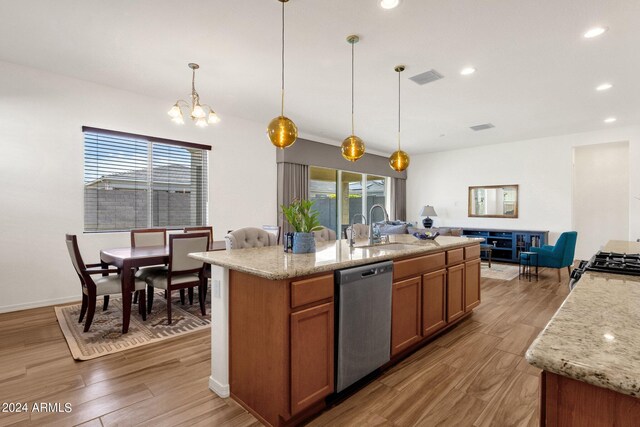 kitchen featuring pendant lighting, light hardwood / wood-style flooring, sink, and stainless steel dishwasher